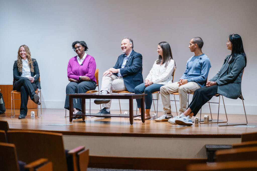 Panel of six people sitting in a semicircle.