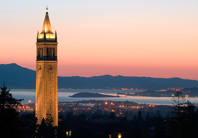 A view of Berkeley and the Bay at sunset, with the UC Berkeley campanile lit up in the foreground